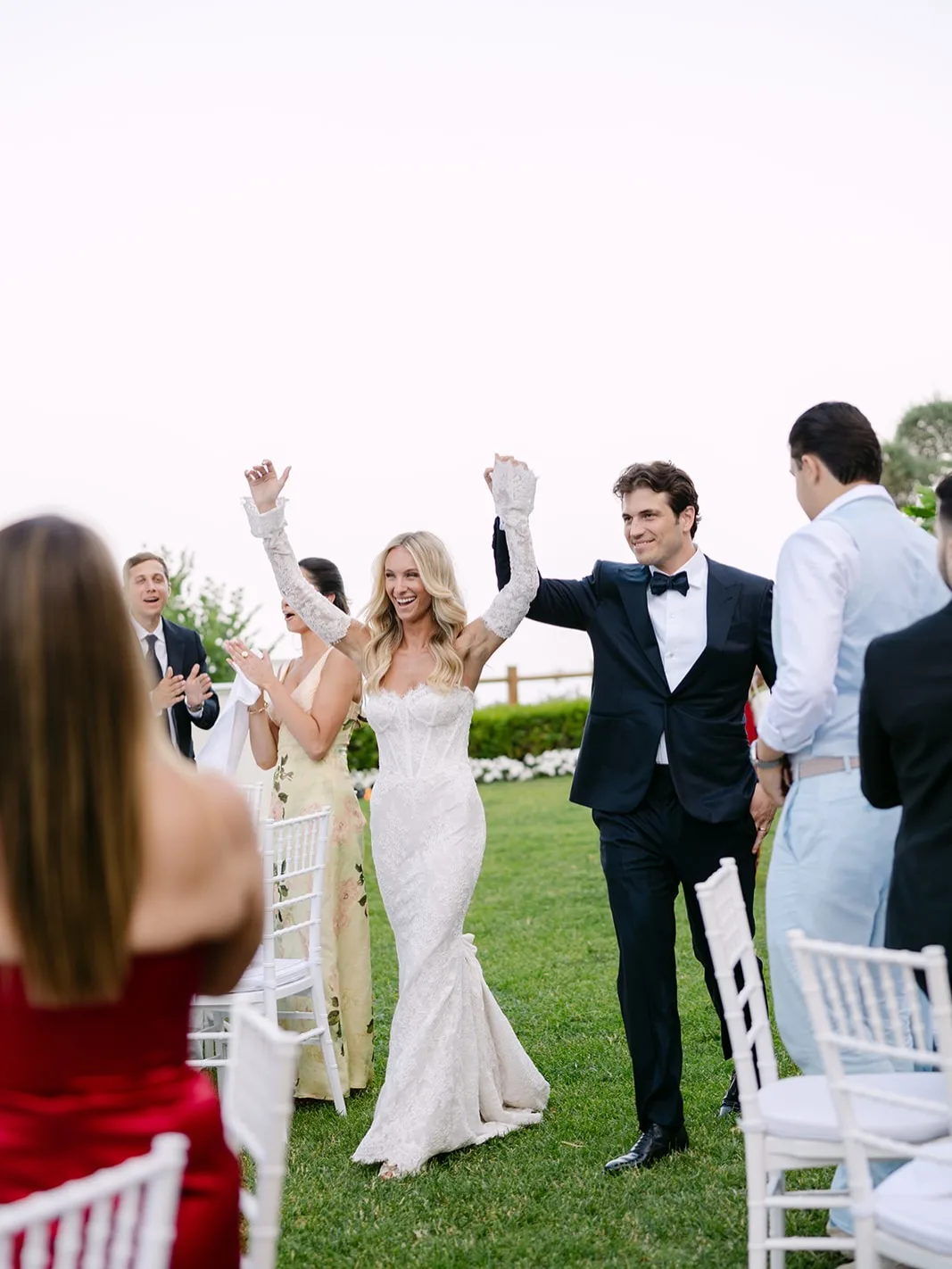 Newlyweds walking through cheering wedding guests