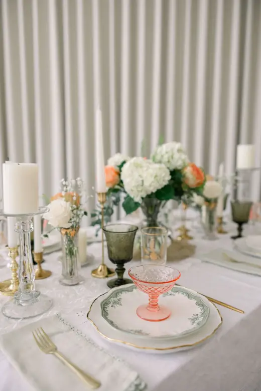 Floral tablescape with candles and vintage glassware