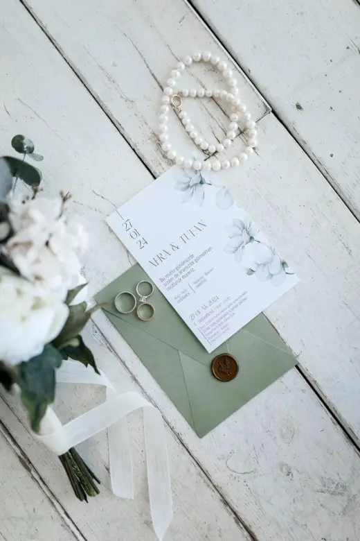 Wedding invitation and rings on ivory paper