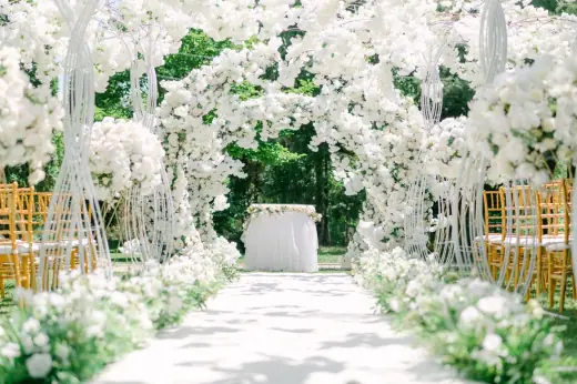 Outdoor wedding ceremony with white floral arches