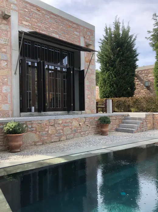 Stone villa and pool within a landscaped garden